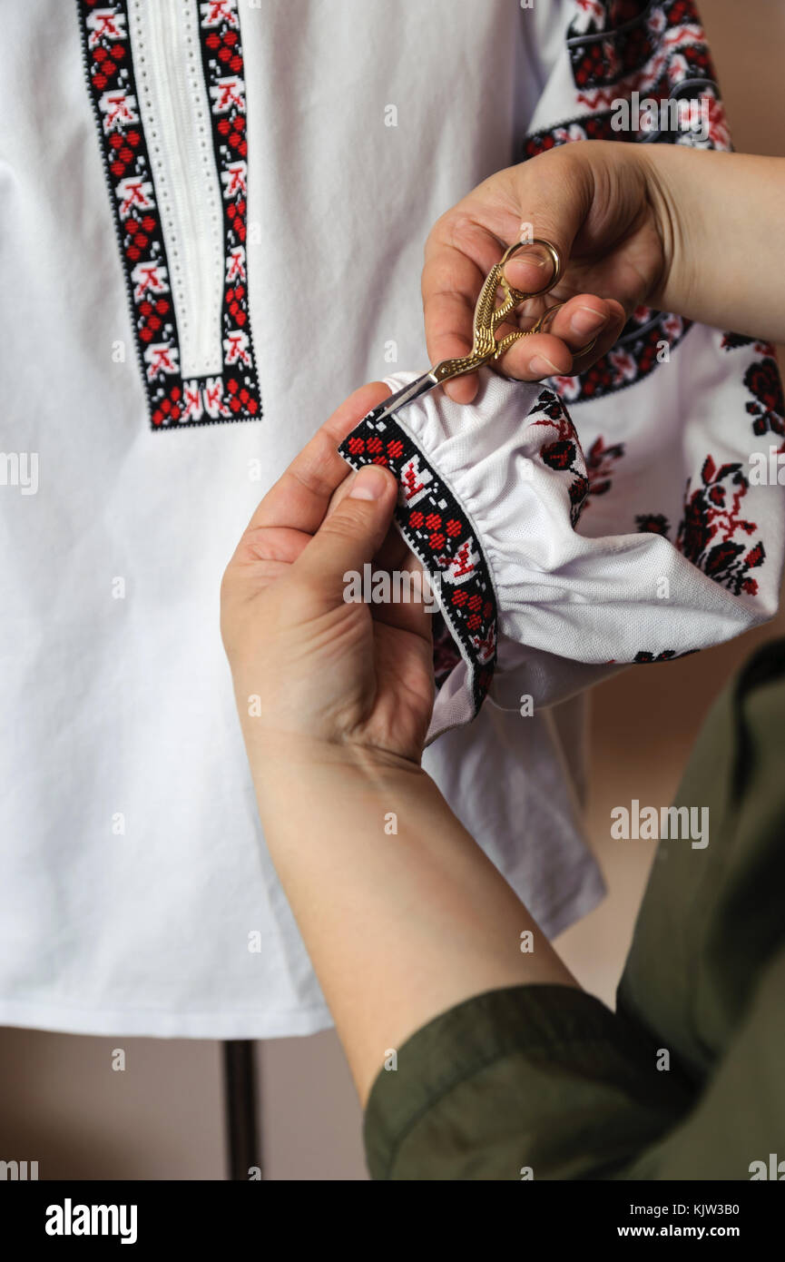 Mujer manos recortar el exceso de hilo camisas bordadas Fotografía de stock  - Alamy