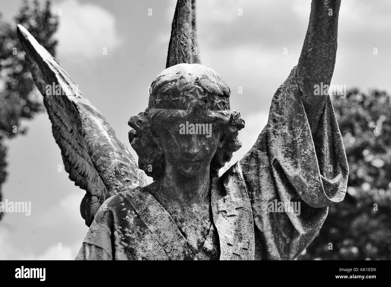 Este ángel se arrodilla encima de un memorial con el epitafio "se siembra en flaqueza, se levantará con potencia". Foto de stock