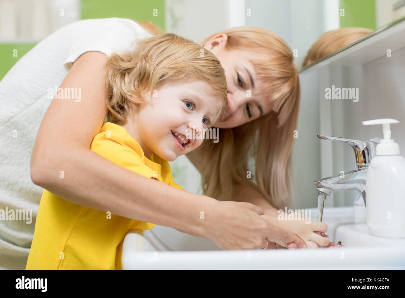 La madre y el niño, hijo de lavarse las manos en el baño. cuidado y preocupación por los niños. Foto de stock