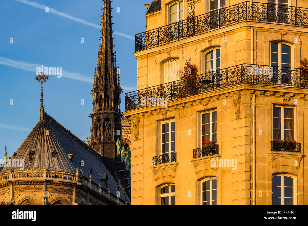 Fachada de edificio haussmaniano al atardecer y el chapitel de la catedral de Notre Dame de París. Ile de la Cite, 4th Arrondissement, París, Francia Foto de stock