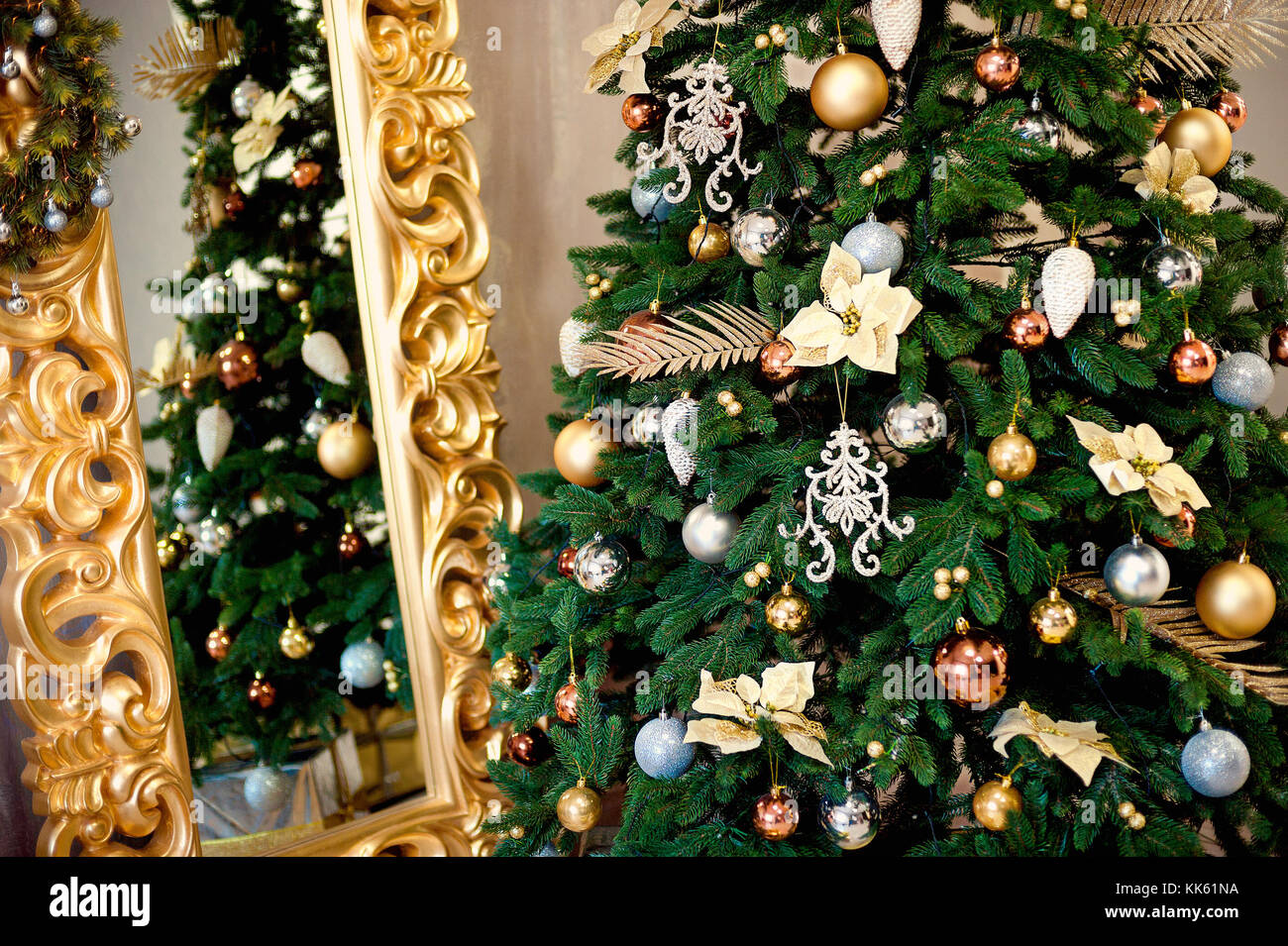 Hermoso árbol de navidad decorado con rojo y chucherías goldish y Garland, en el nuevo año con chimenea y calcetines de fondo. La idea de postales. soft focus. Foto de stock