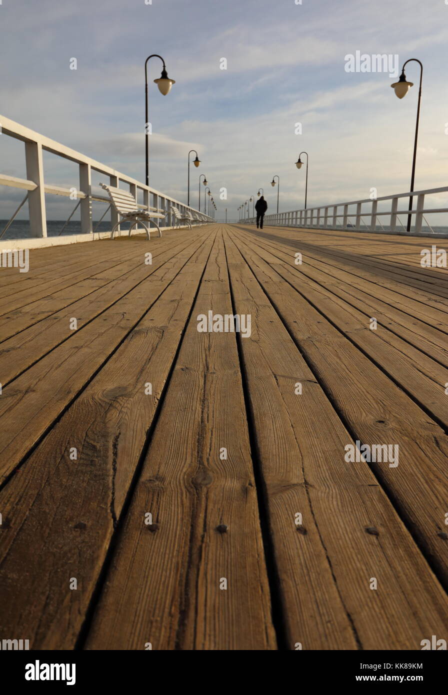 Solo hombre caminando el largo muelle de madera Foto de stock