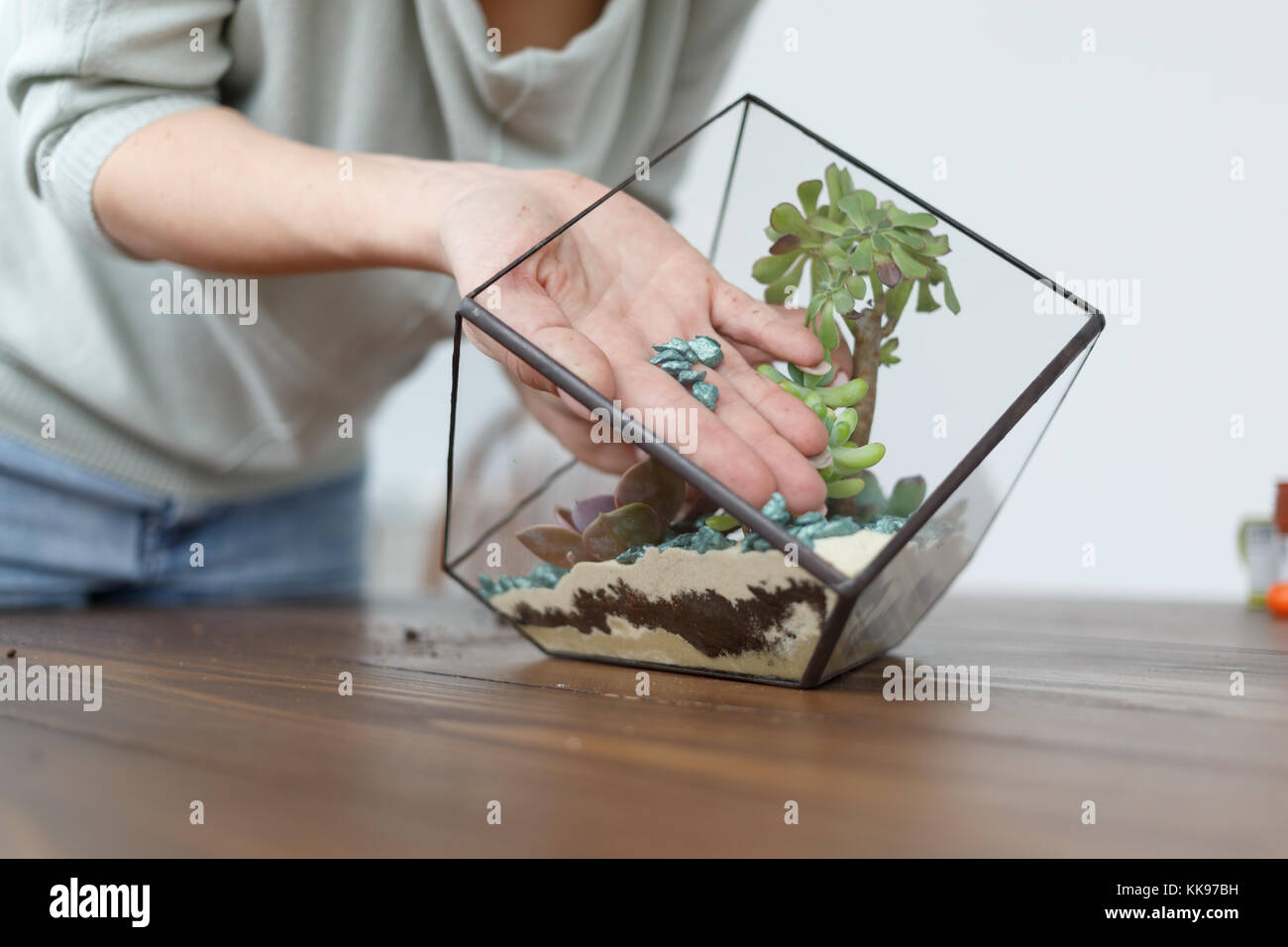 Imagen de mujer mostrando floristería master class sobre decisiones florarium con piedras Foto de stock