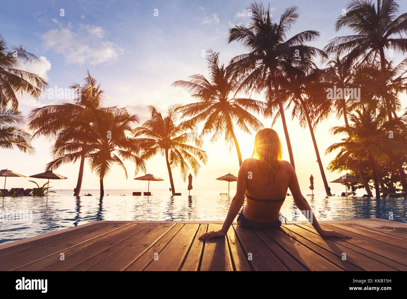 Mujer disfrutando de las vacaciones en el lujoso hotel resort frente al mar con piscina y cerca de la playa lansdcape tropical Foto de stock
