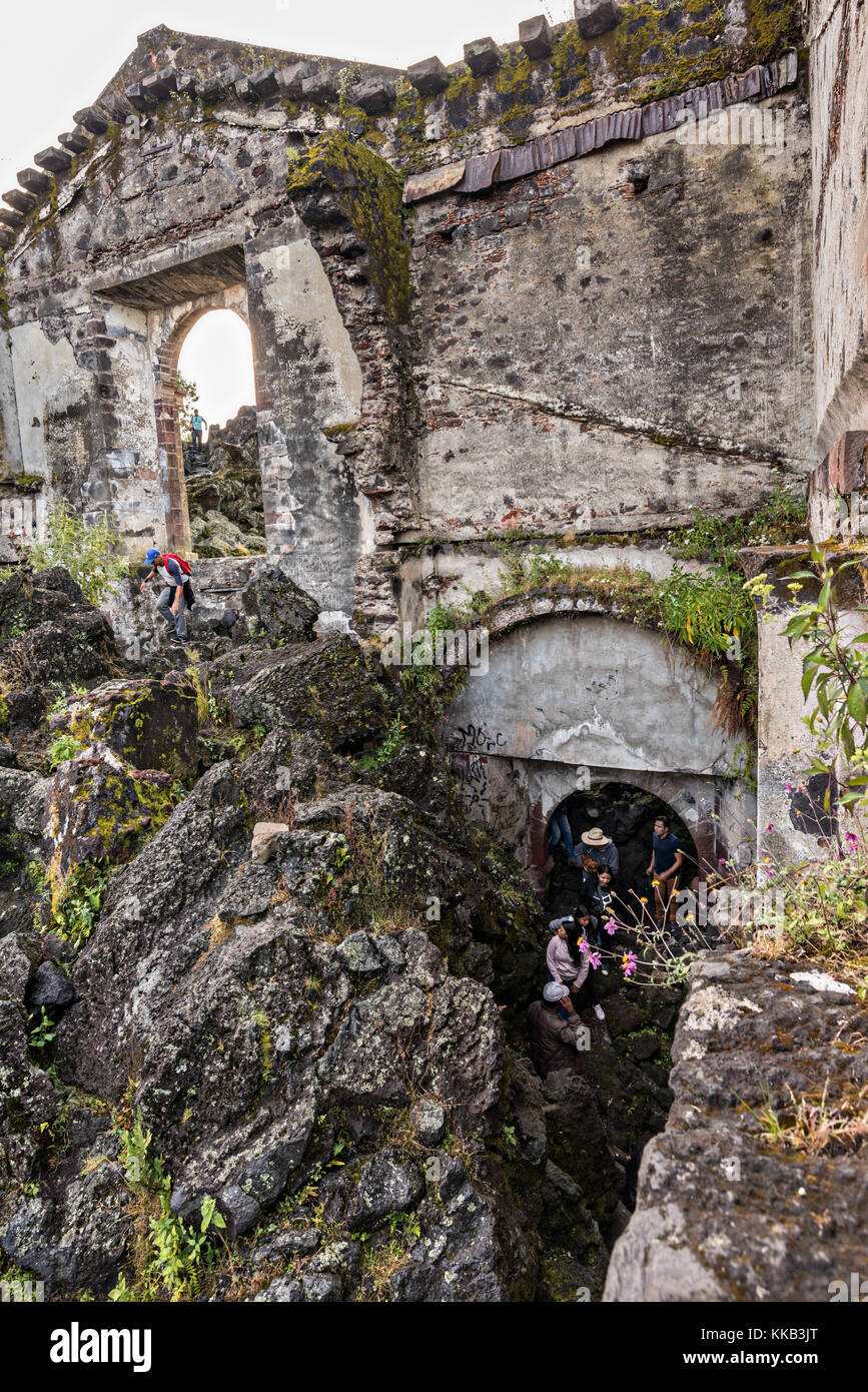 Los turistas visitan una habitación bajo la iglesia de San Juan Parangaricutiro sacando de un mar de roca de lava seca en el remoto pueblo de San Juan Parangaricutiro, Michoacán, México. Esta Los turistas visitan una habitación bajo la iglesia de San Juan Parangaricutiro sacando de un mar de roca de lava seca en el remoto pueblo de San Juan Parangaricutiro, Michoacán, México. Esta