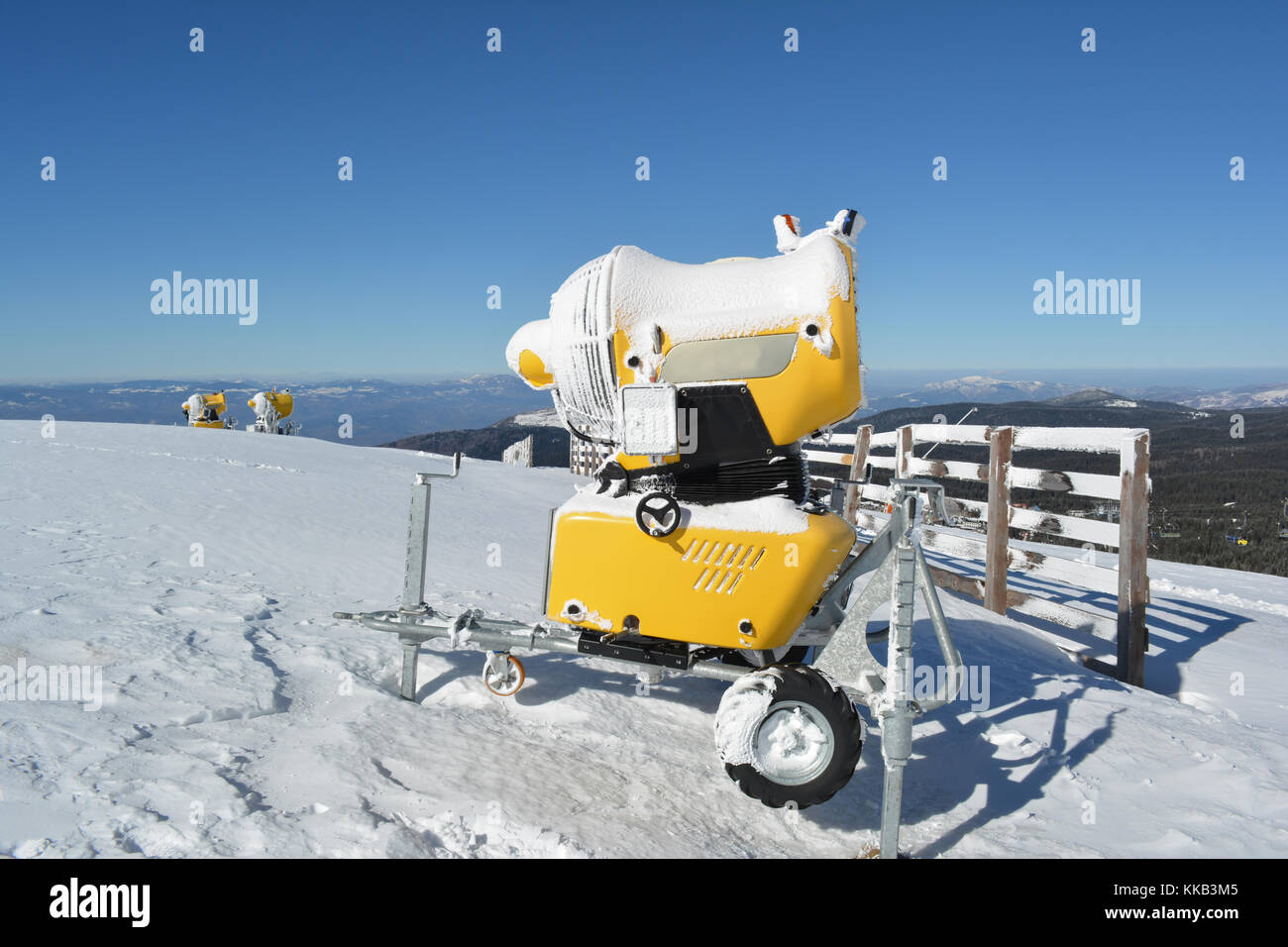 Tres cañones de nieve en la cima de la montaña, listo para extender la temporada de esquí. Foto de stock