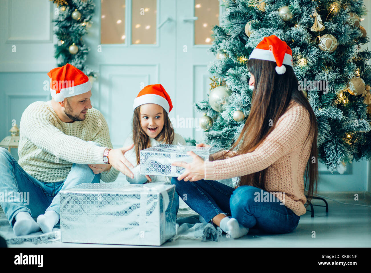 Los padres con Little Girl sorprendió a los regalos de Navidad para el  nuevo año Fotografía de stock - Alamy