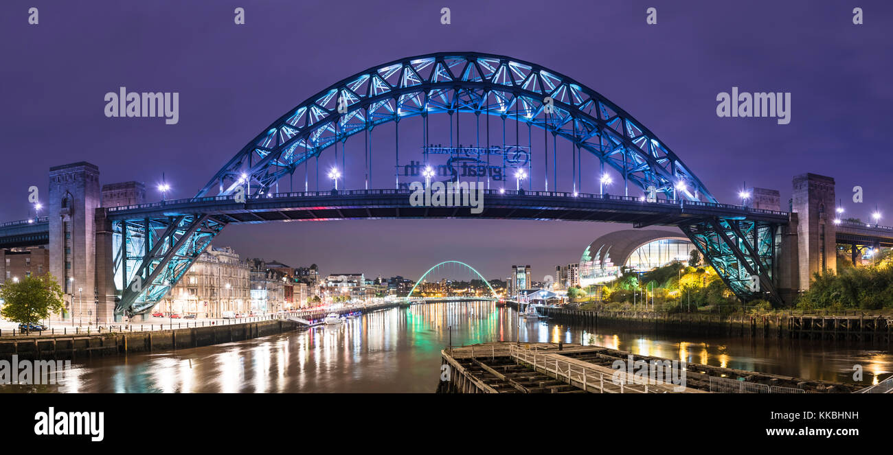 Foto nocturna mirando a lo largo del río Tyne hacia el puente Tyne y el puente Gateshead Millennium, Newcastle upon Tyne, Tyne y Wear, Inglaterra Foto de stock