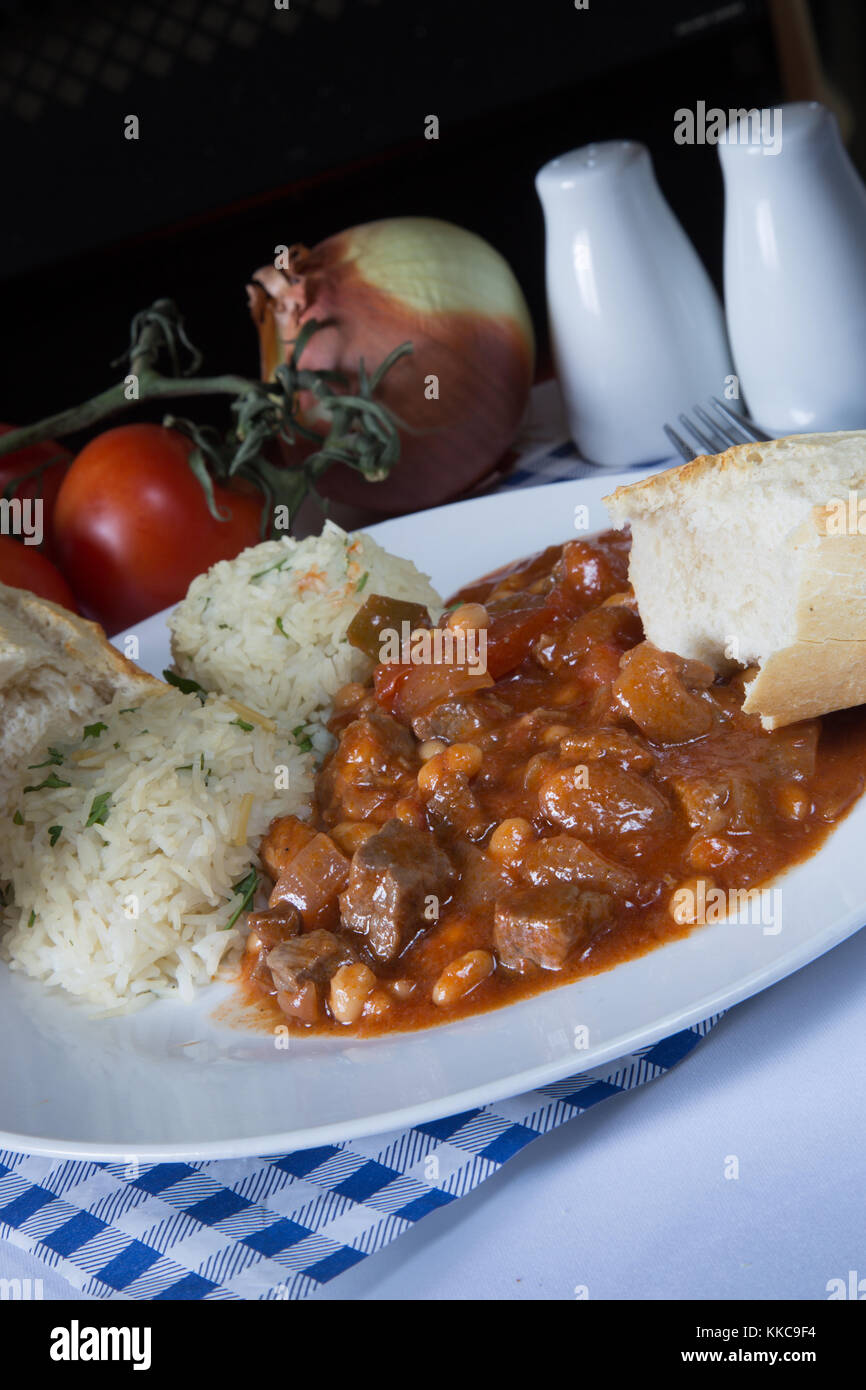 Un plato de judías blancas turco tradicional puchero, Etli kuru fasulye, con Orzo pilau arroz y pan crujiente. Foto de stock