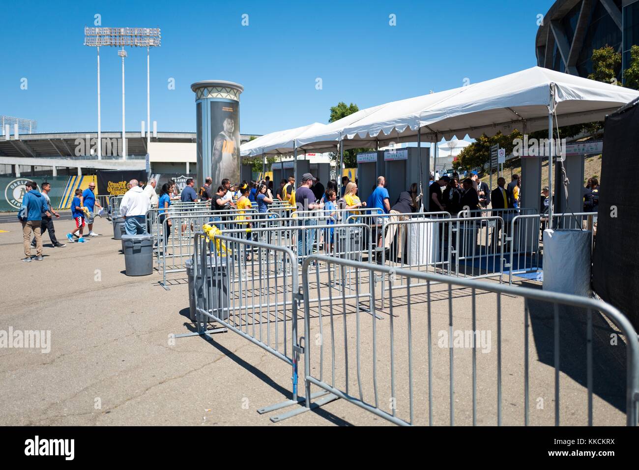 Antes del Juego 2 de la final de la Asociación Nacional de Baloncesto (NBA) entre los Guerreros del Estado de Oro y los Cavaliers de Cleveland, los aficionados entran en detectores de metales fuera del Oracle Arena en Oakland, California, 5 de junio de 2016. Foto de stock