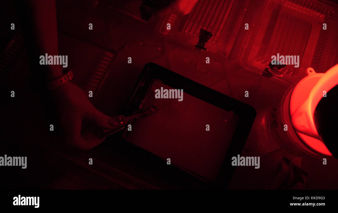Proceso de impresión en el cuarto oscuro, el fotógrafo con la ... Proceso de impresión en el cuarto oscuro, el fotógrafo con la ...