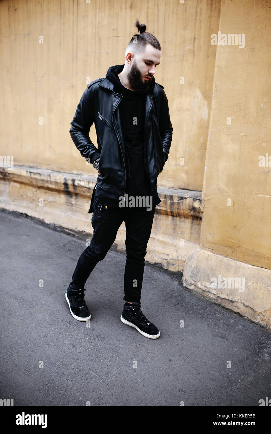 Joven barbudo moderno hombre de negro con ropa estilo está caminando en la  calle Fotografía de stock - Alamy