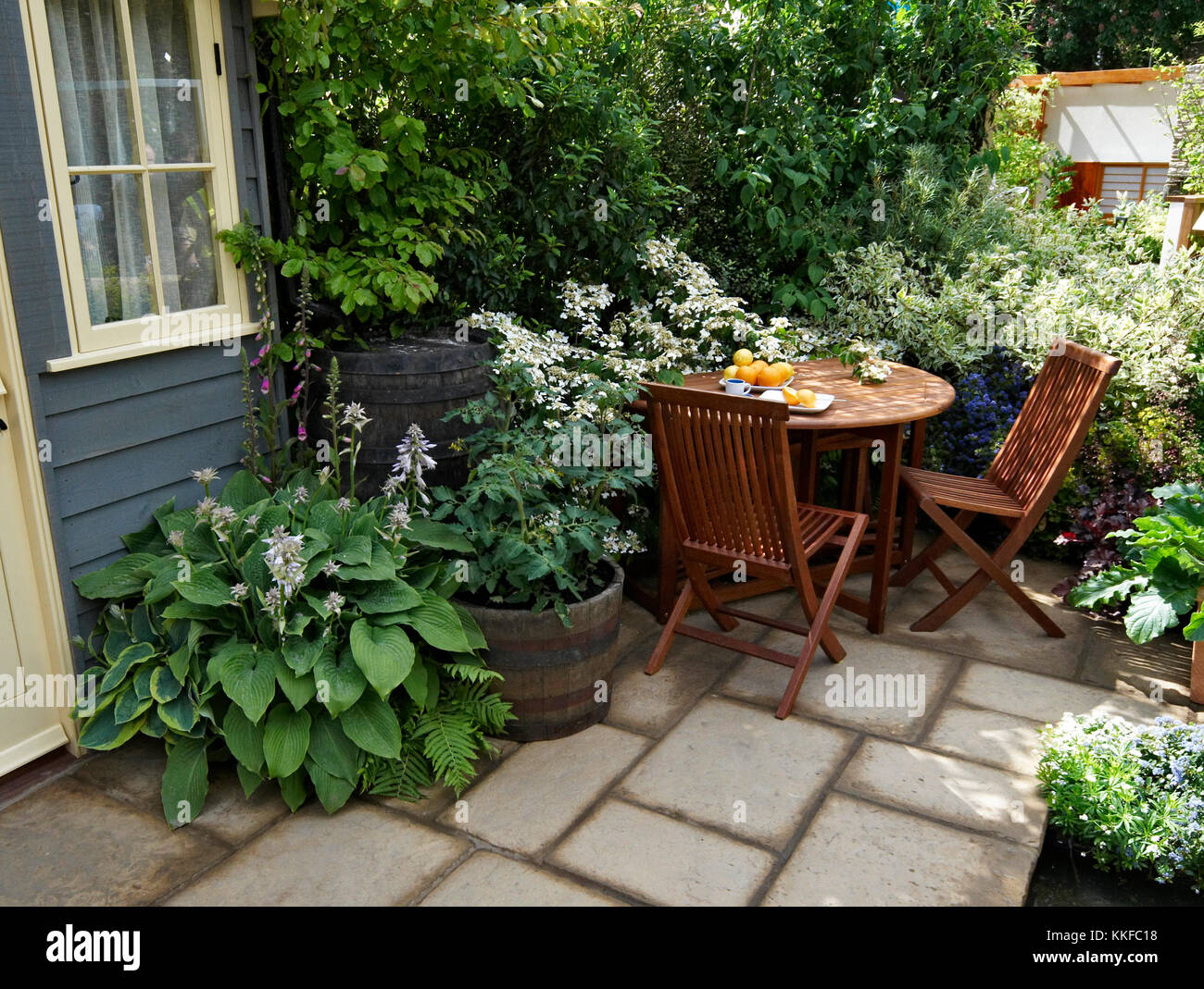 Sentarse en un pequeño patio jardín urbano con terrazas para comer Foto de stock