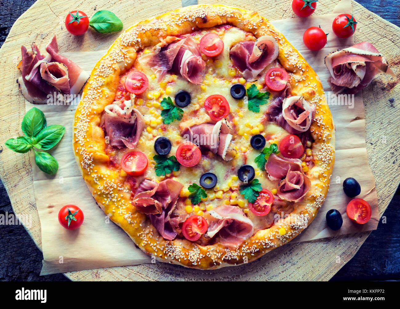 Pizza gourment caseros con jamón y verduras desde arriba sobre la mesa de madera Foto de stock