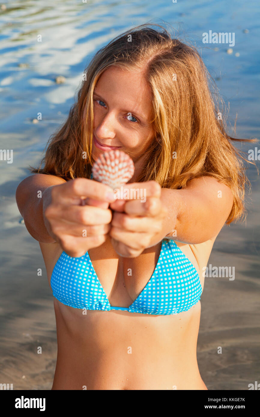 Estilo de vida familiar feliz mujer sonriente joven en bikini mantenga en  manos caracol. verano viajes, ocio y actividades recreativas en vacaciones  en la playa Fotografía de stock - Alamy