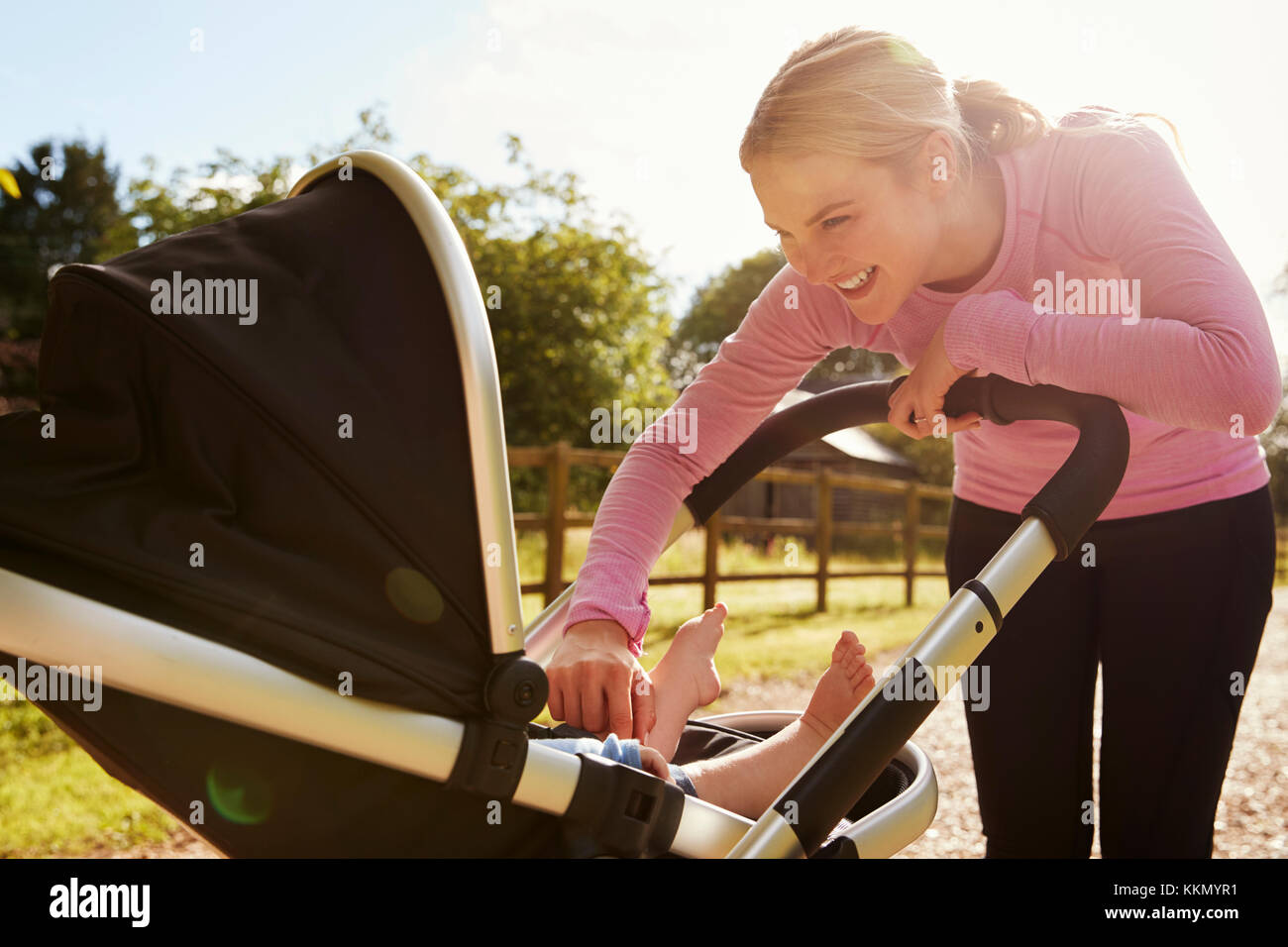 La madre ejerce Ejecutando mientras empujando cochecitos de bebé Foto de stock