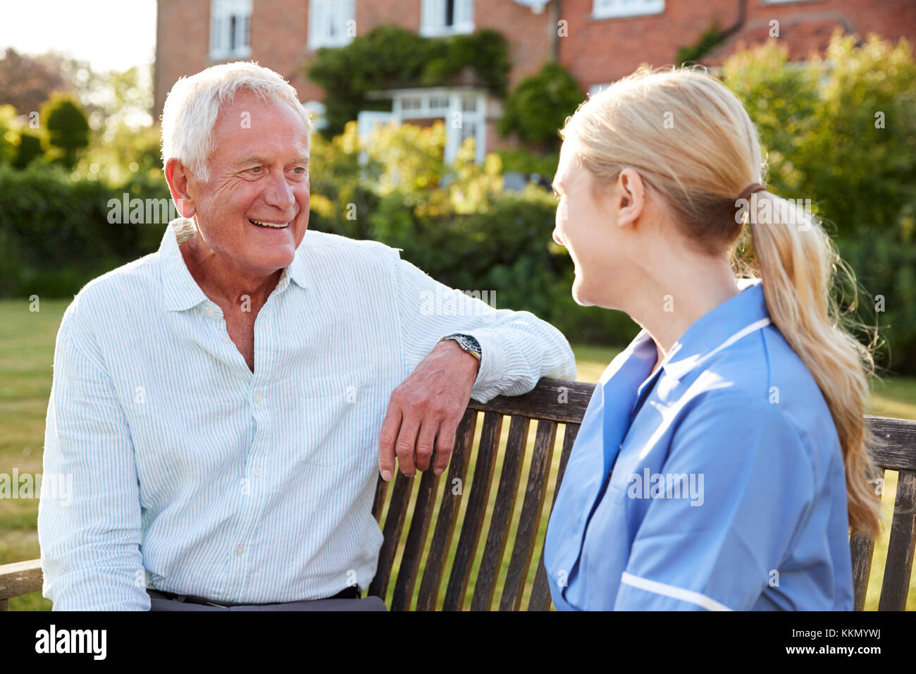 Hablar con la enfermera hombre Senior en atención residencial Home Foto de stock