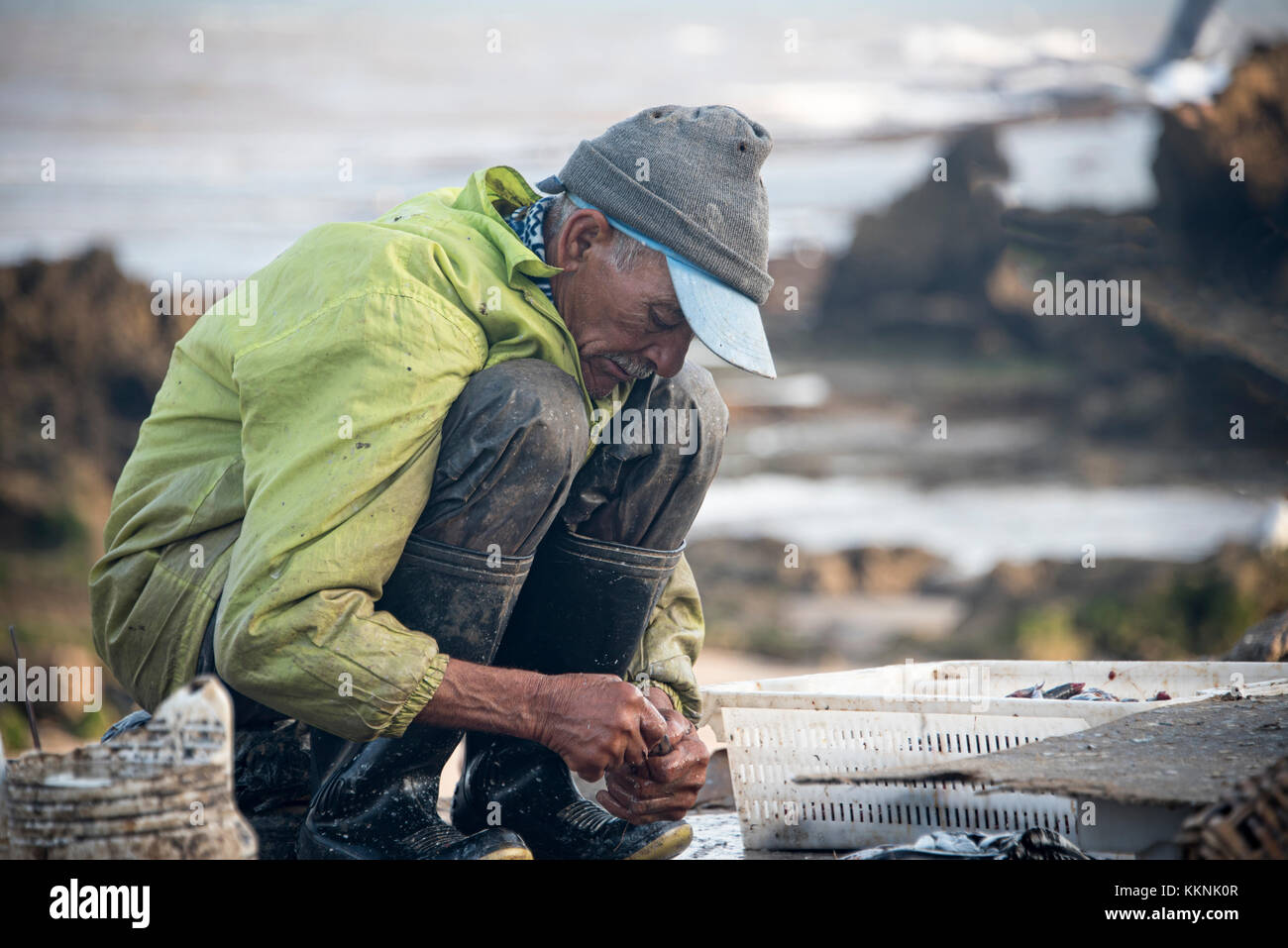 Essaouria, Marruecos - Septiembre 2017: Pescador preparando cebo en la mañana temprana Foto de stock
