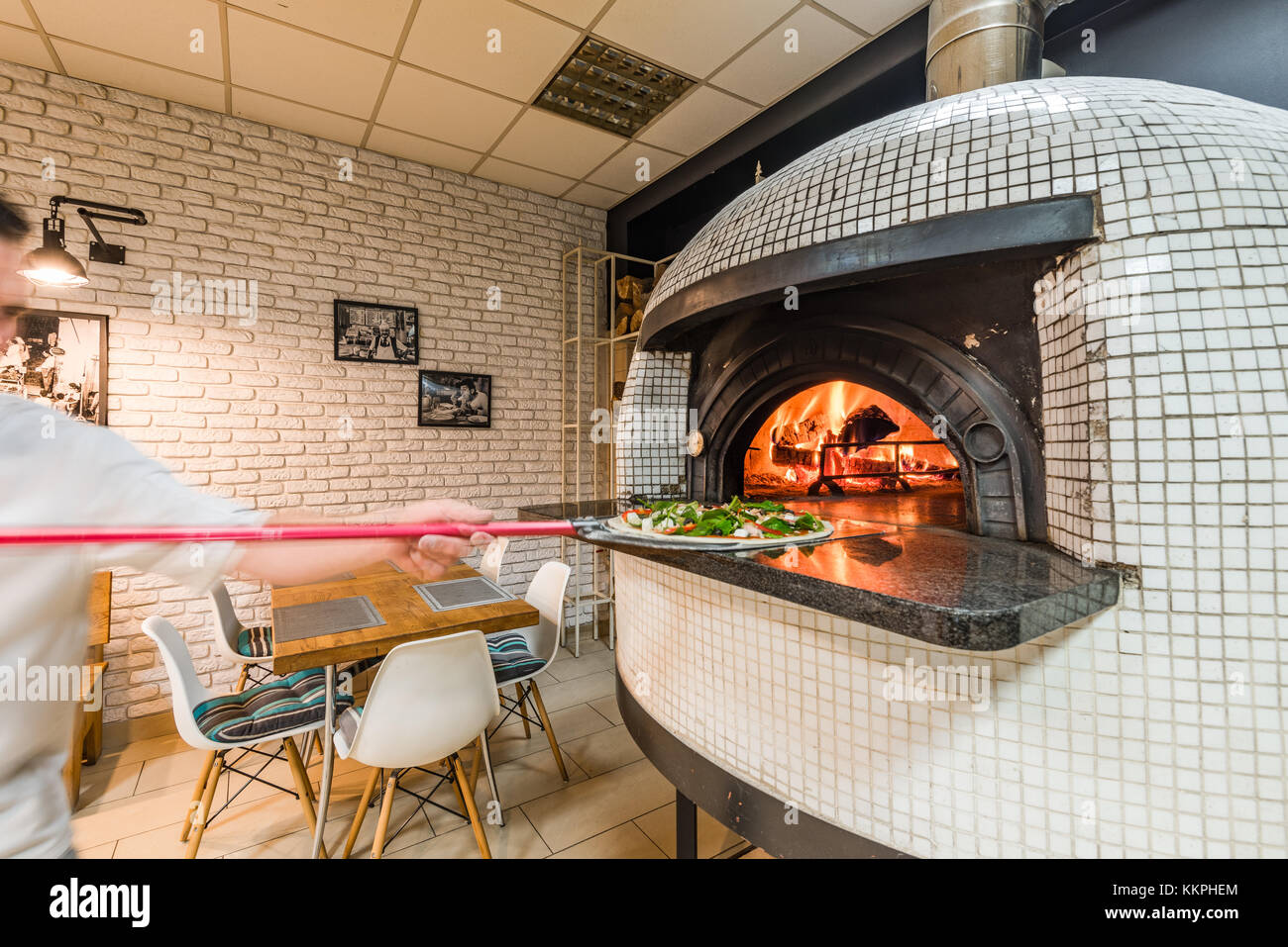 Guapo pizzaiolo hombre woodfired pizza hornear en horno en la pizzería  local Fotografía de stock - Alamy