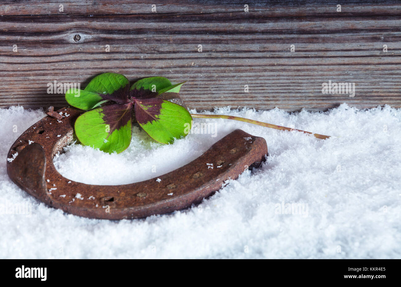 La herradura y trébol en la nieve Foto de stock