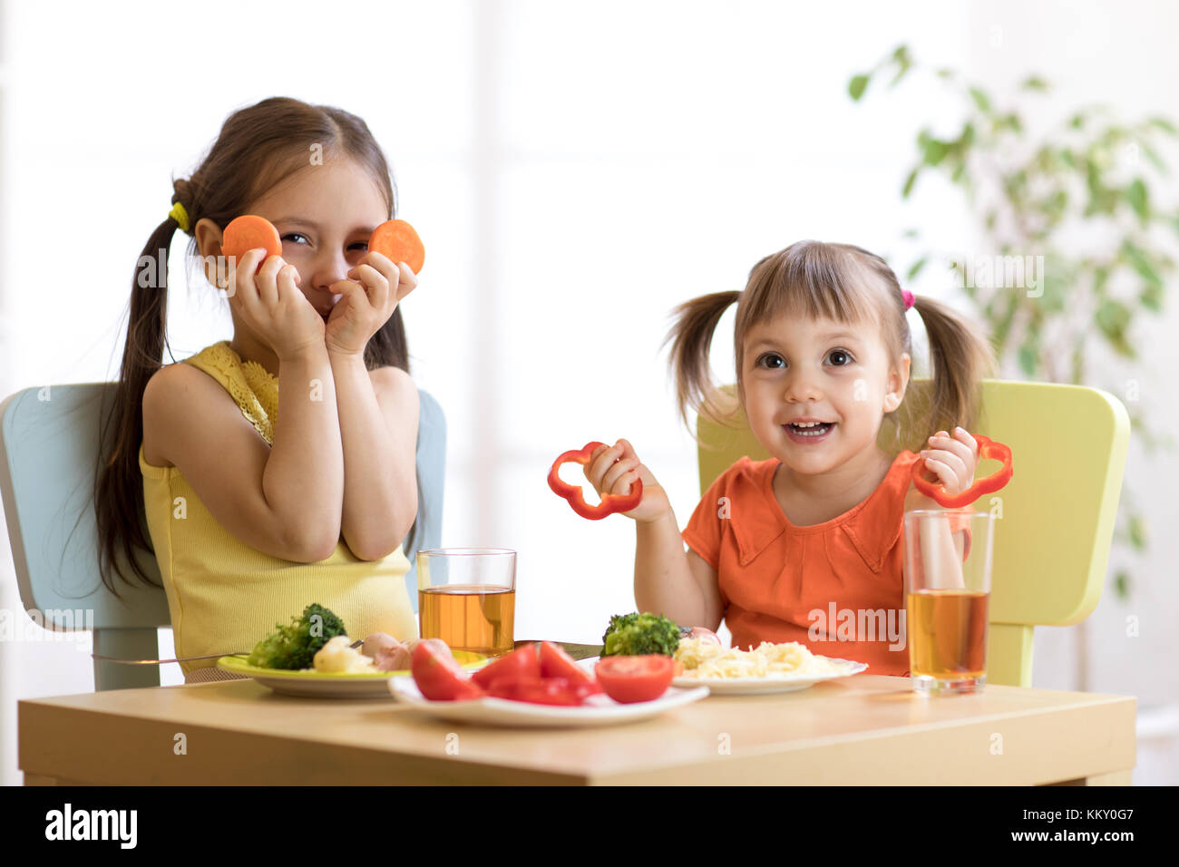 Gracioso niños jugando y comiendo en kindergarten. Foto de stock