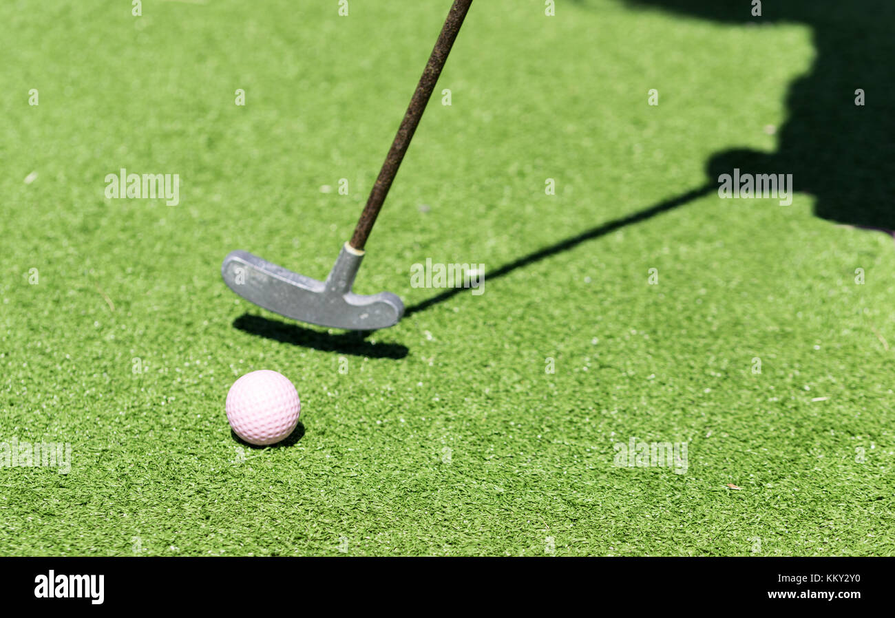 Raqueta de golf en miniatura y una sombra del jugador Foto de stock