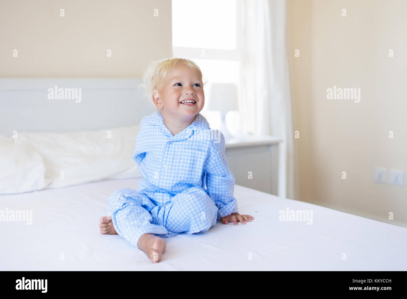 Adorable Niña Jugando Con Lámpara De Noche En Vivero. Niño Feliz Sentado En  La Cama Con Luz Nocturna. Niño Pequeño En Casa Por La Noche Antes De Dormir  Fotos, retratos, imágenes y