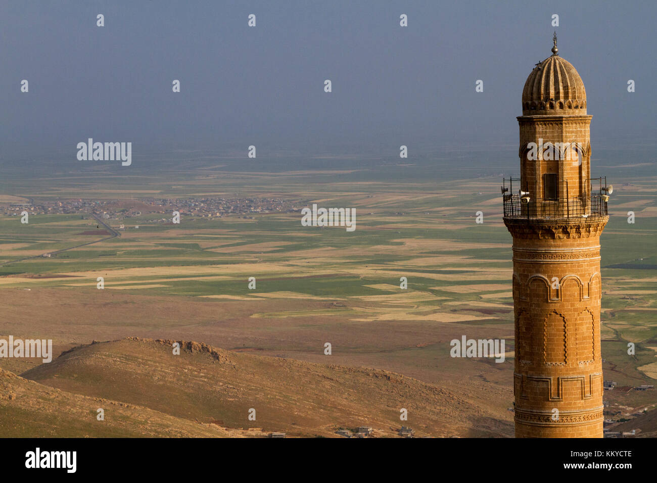 Minarete y la cúpula de la mezquita de Mardin, Turquía con la llanura de Mesopotamia y la frontera con Siria en el fondo. Foto de stock