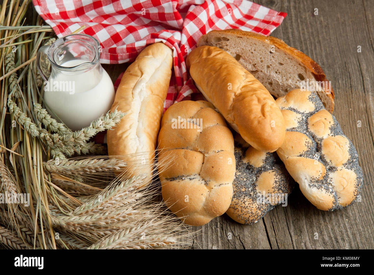 Mucho de pan, una jarra de leche y oído seco de centeno sobre mesa de  madera antigua Fotografía de stock - Alamy