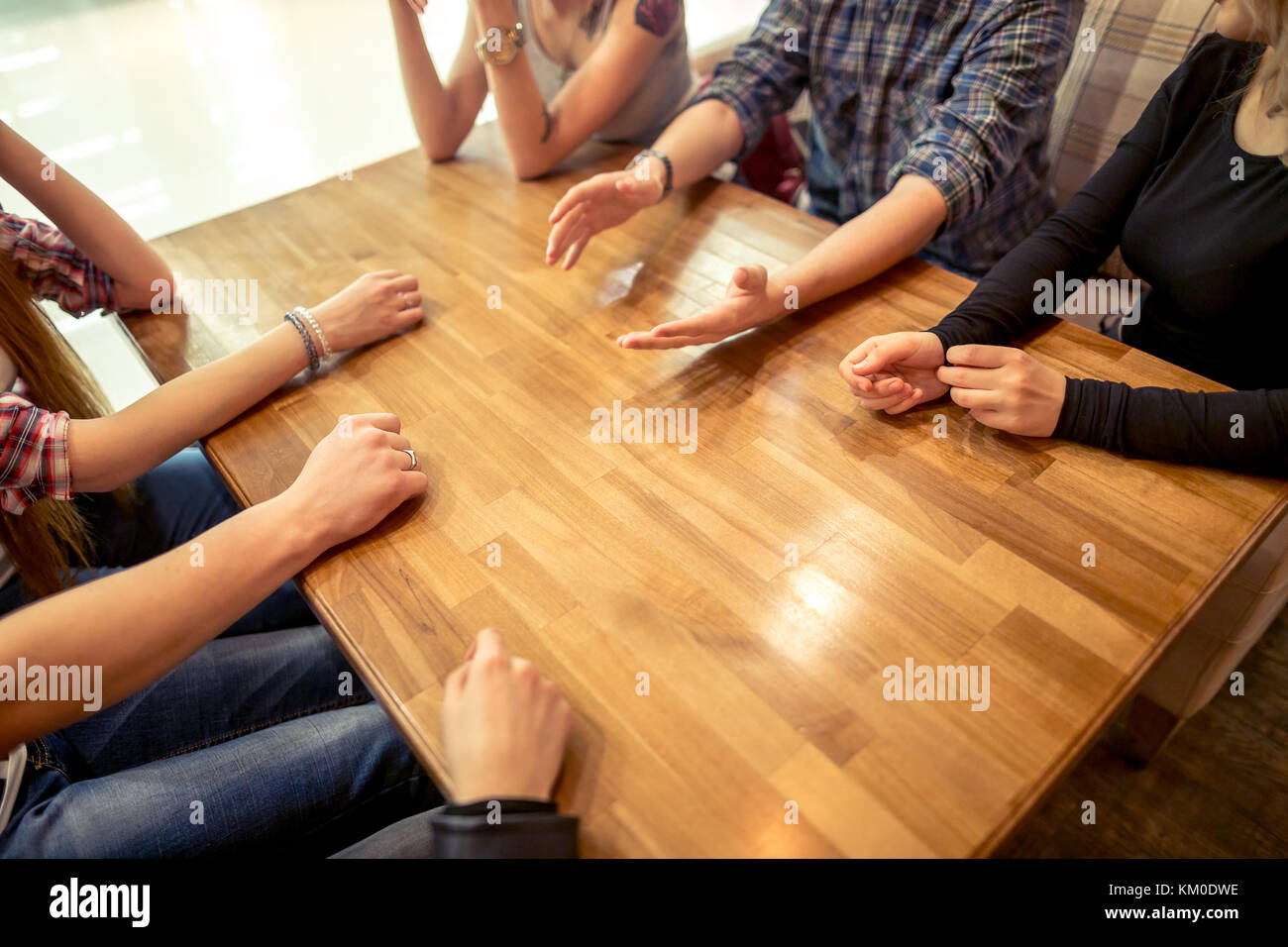 Un grupo de estudiantes sentados en una cafetería mirarse Foto de stock