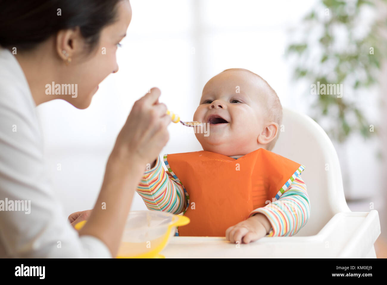 Madre alimentando a su bebé con cuchara. madre dando