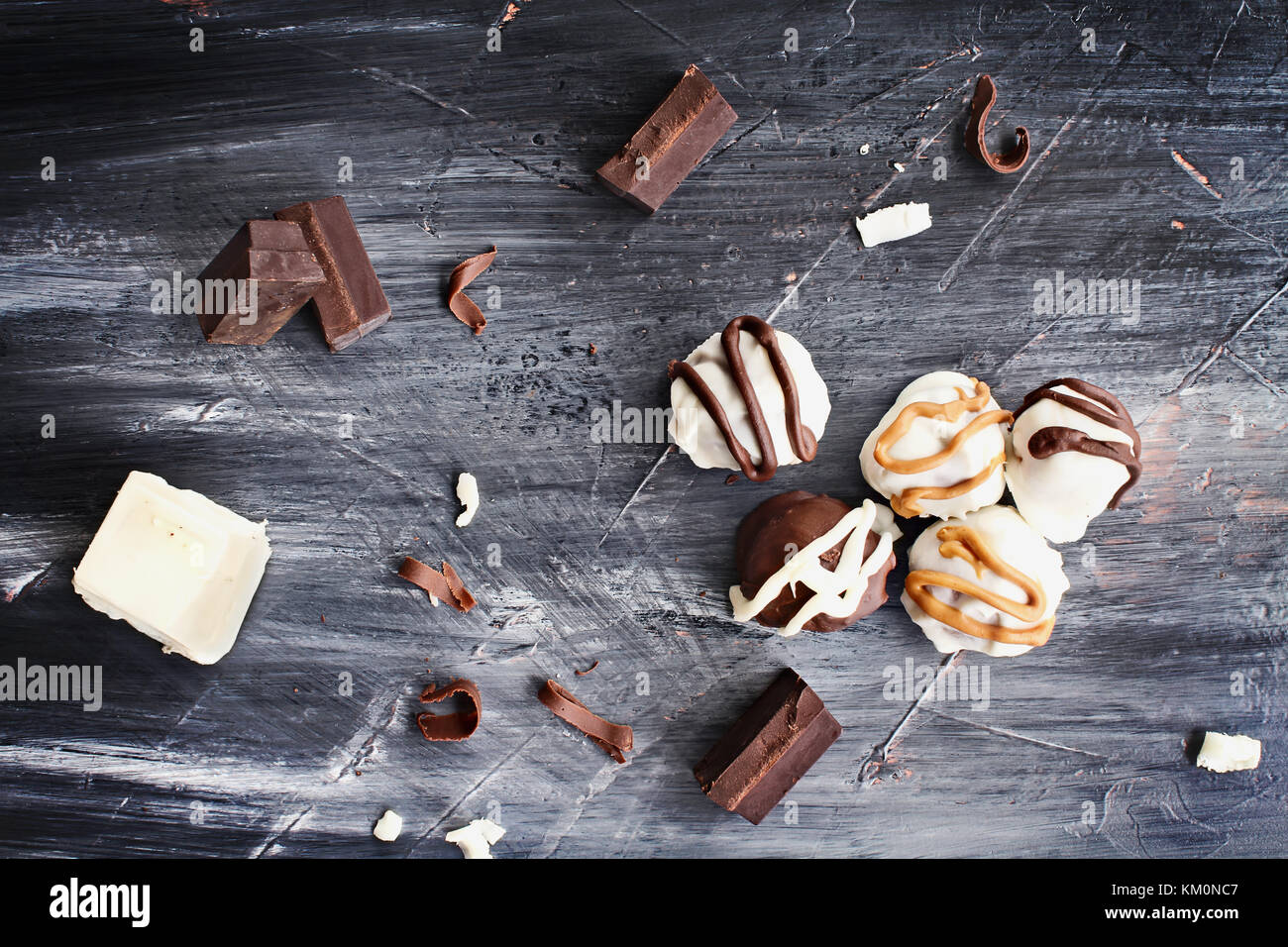 Trufas de chocolate oscuro y blanco para navidad o san valentín con chocolate y virutas de corteza alrededor de ellos. Foto de stock
