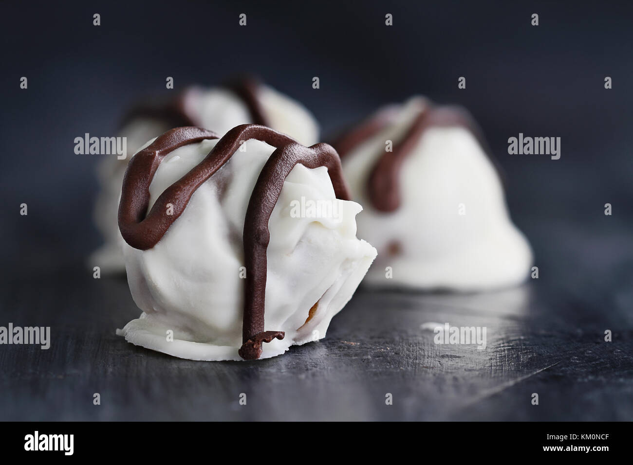Trufas de chocolate blanco para navidad o san valentín rociados con chocolate oscuro. la extrema profundidad de campo con el enfoque selectivo en dulces Foto de stock
