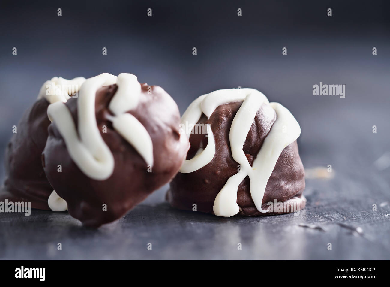 Trufas de chocolate oscuro para navidad o san valentín rociados con chocolate blanco. la extrema profundidad de campo con el enfoque selectivo en dulces Foto de stock