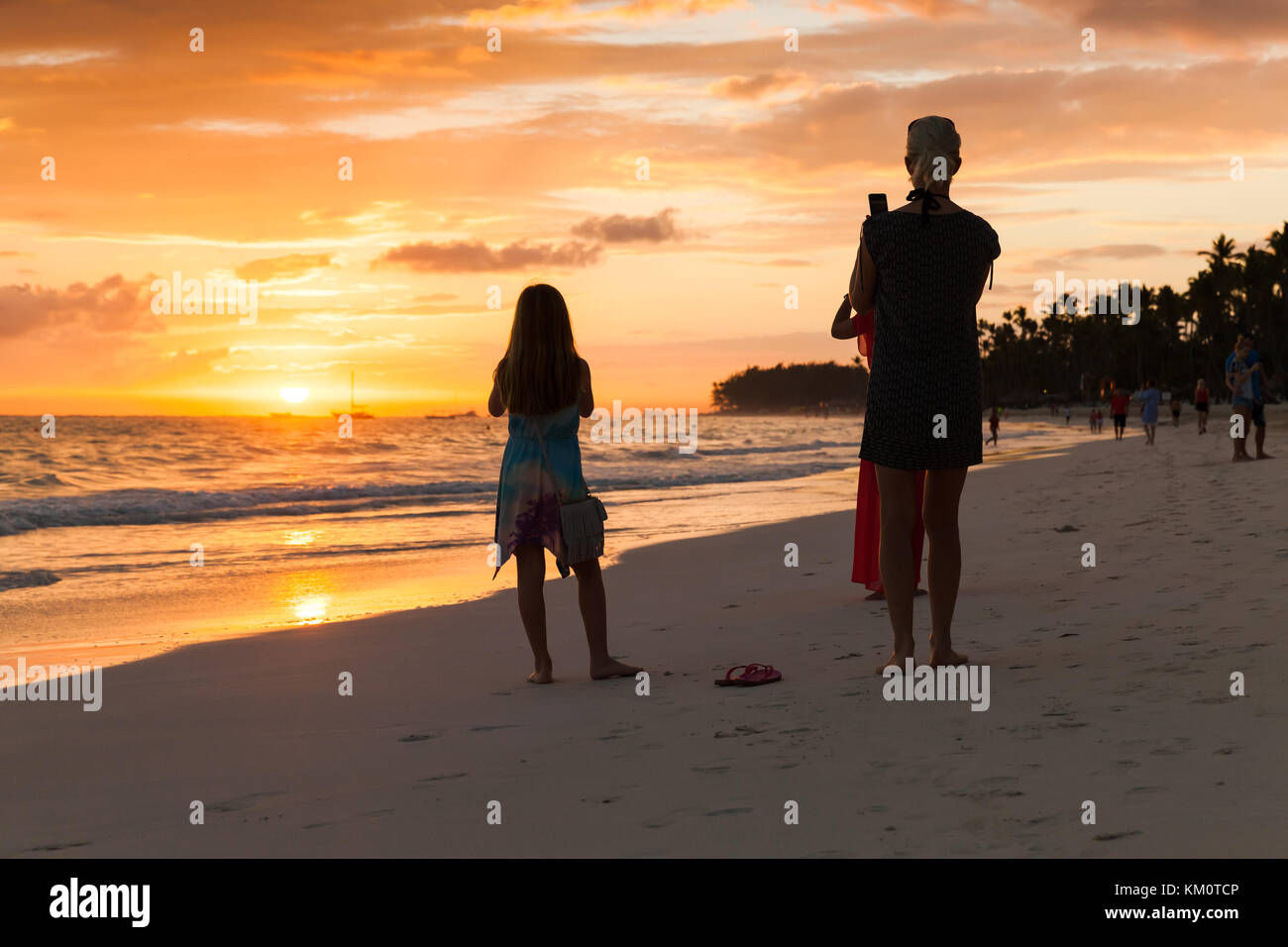 Punta Cana, República Dominicana - 5 de enero de 2017: el turista toma fotos de amanecer con smartphones, playa de Punta Cana. Foto de stock