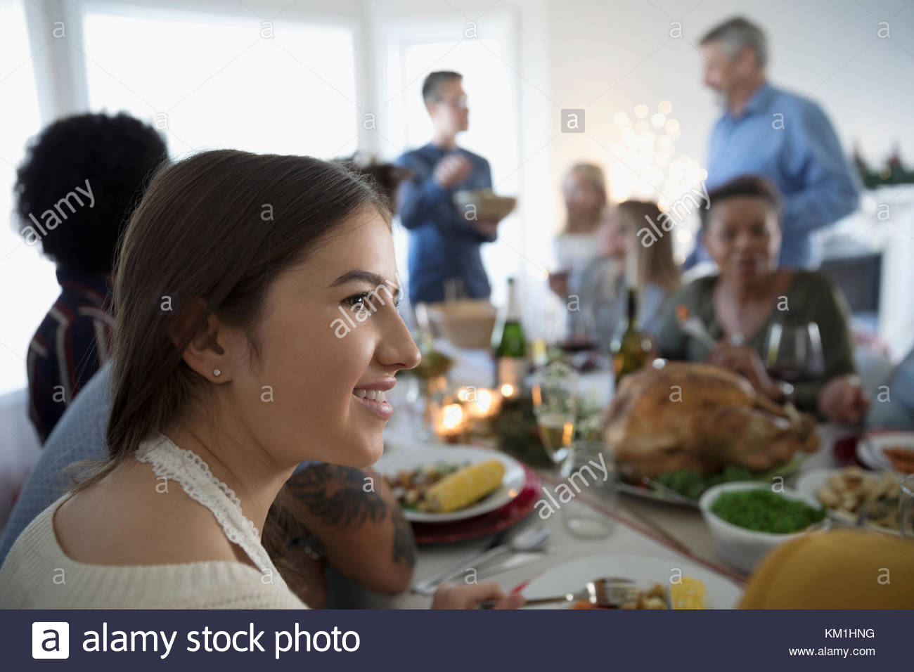 Adolescente sonriente disfrutando de Turquía la cena de Navidad con la familia en la mesa Foto de stock