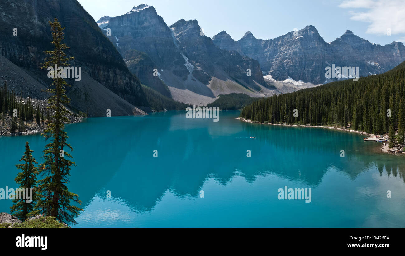 Los picos de las Montañas Rocosas se refleja en las tranquilas aguas del Lago Moraine, Alberta Foto de stock