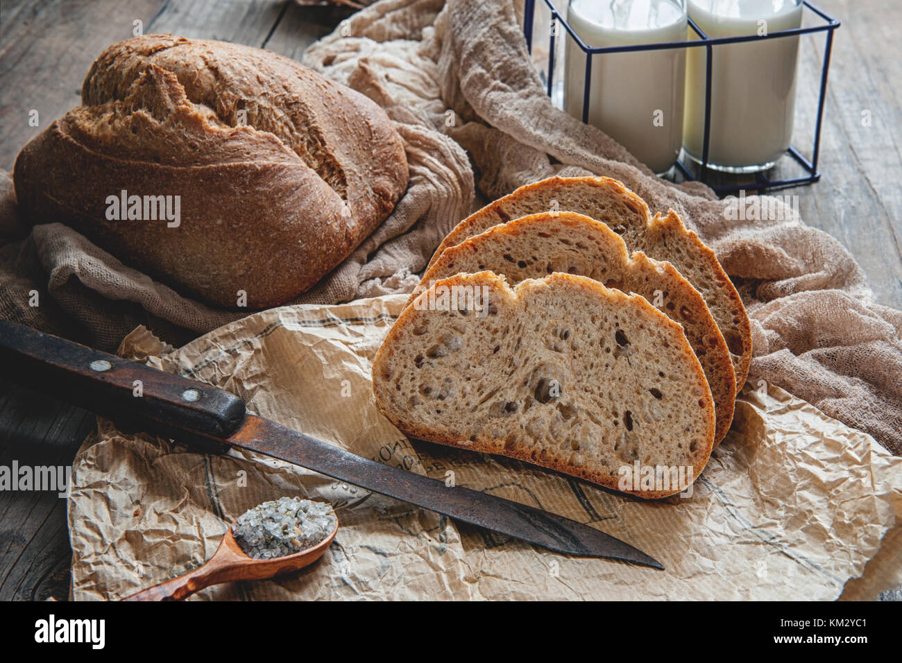 Una hermosa hogaza de pan de masa fermentada de trigo blanco en una placa en un borde de lino. Pasteles caseros. Foto de stock
