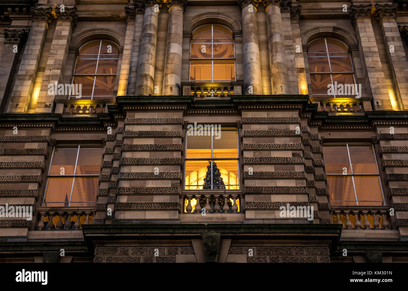 Cerca del edificio victoriano, sede del Bank of Scotland, el montículo, iluminado al anochecer con el árbol de Navidad en la ventana, Edimburgo, Escocia, Reino Unido Foto de stock