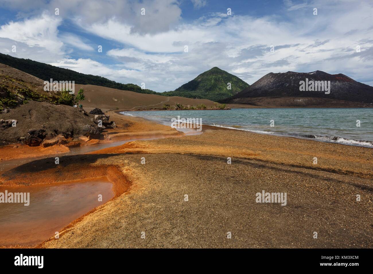 Residuos de naranja brillante reside en torno al manantial de agua caliente, al pie del volcán Tavurvur Foto de stock