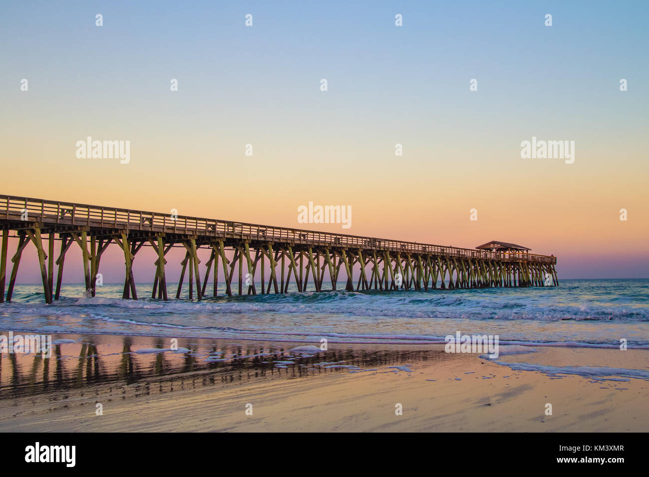 En Myrtle Beach, Carolina del Sur. Seascape en Myrtle Beach, Carolina del Sur con un largo muelle de madera y el horizonte del atardecer sobre el Océano Atlántico. Foto de stock