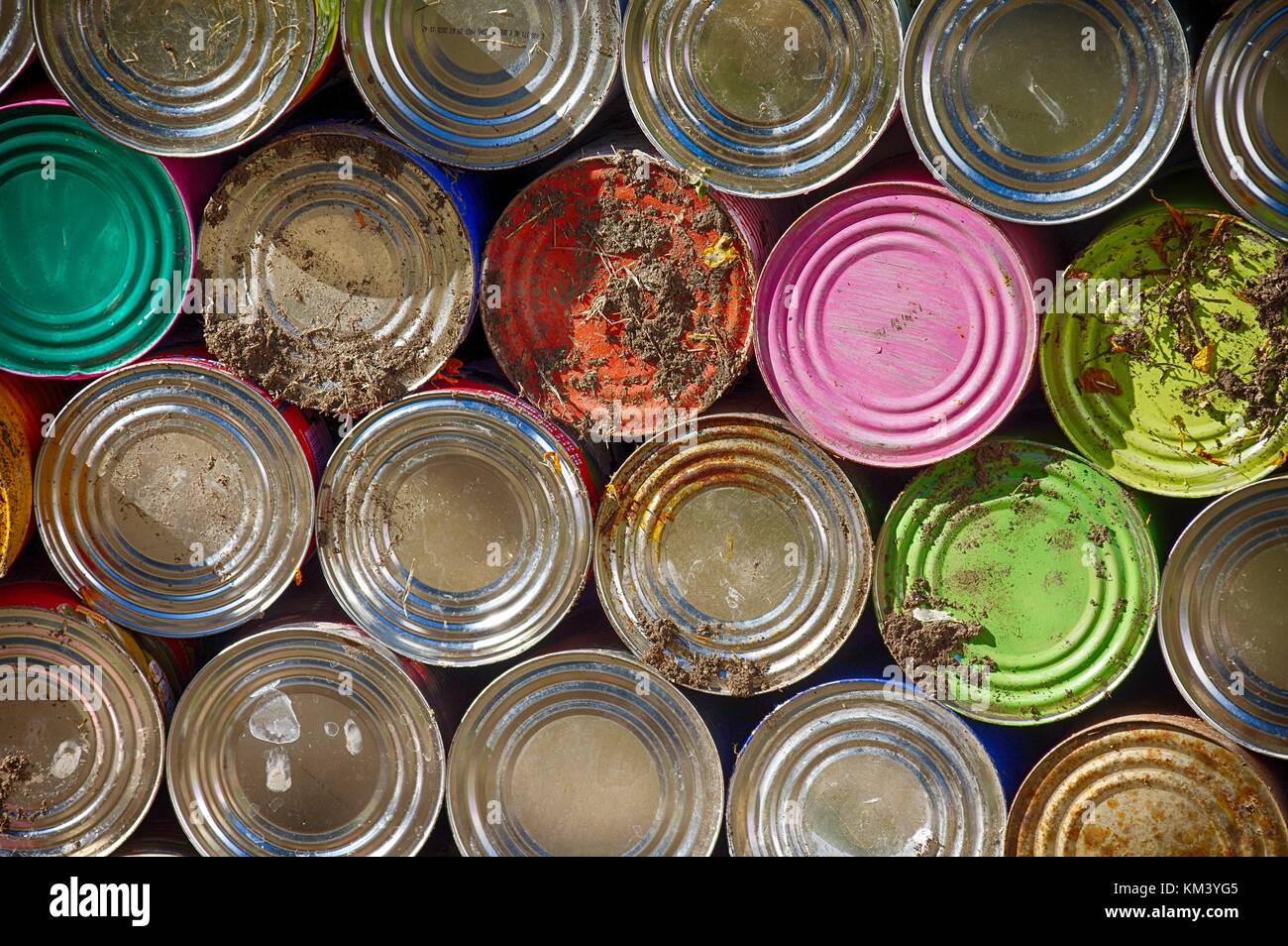 Colorido latas apiladas a lo largo de la pared de un cementerio en México Foto de stock