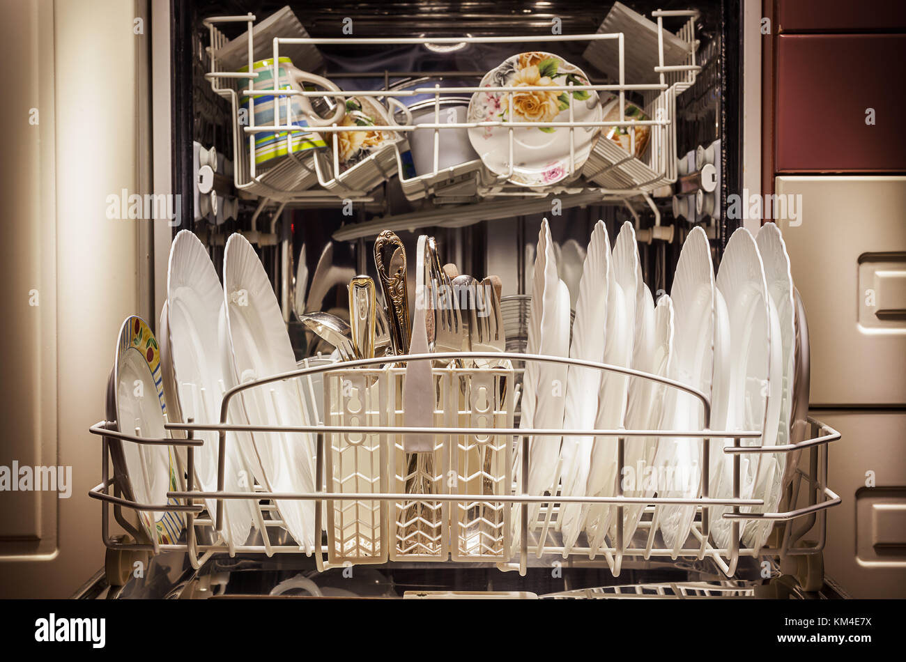 Platos limpios y accesorios en el lavavajillas después de lavar. Foto de stock