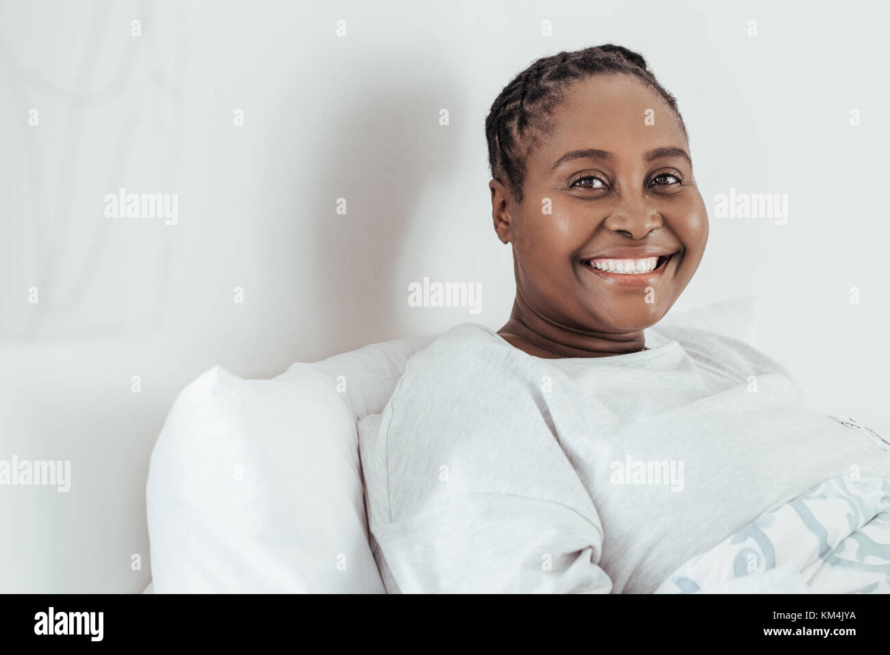 Mujer africana adulta sentada en la cama del hospital Foto de stock