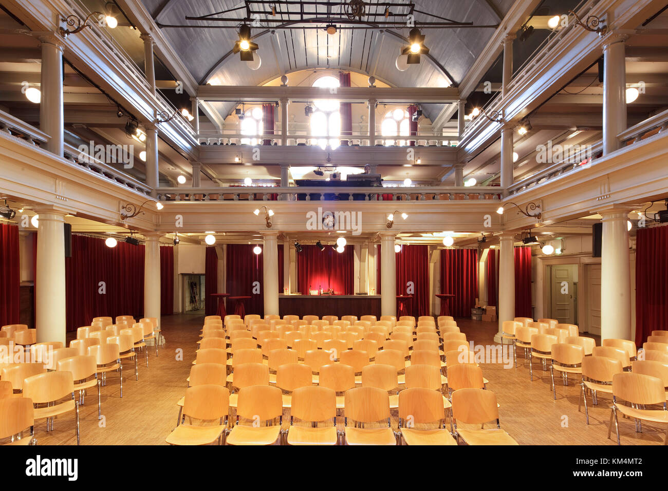 Vista desde el escenario hacia la parte trasera del auditorio, con asientos de madera. De Rode Hoed, Centro Cultural, Amsterdam, Países Bajos. Arquitecto: Desconocido, 1630. Foto de stock