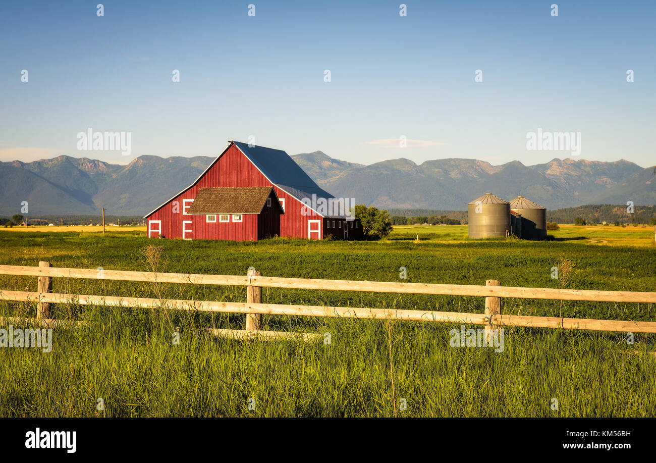 Noche de verano con un granero rojo en la zona rural de montana Foto de stock