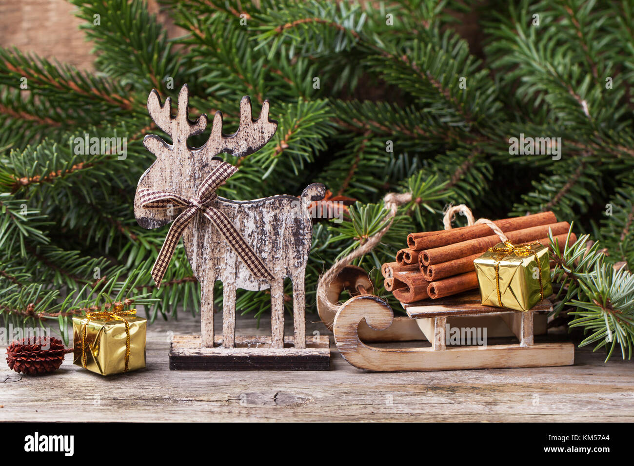 Tarjeta de navidad con ciervos de madera, trineo, canela y regalos de navidad más antiguo fondo de madera Foto de stock
