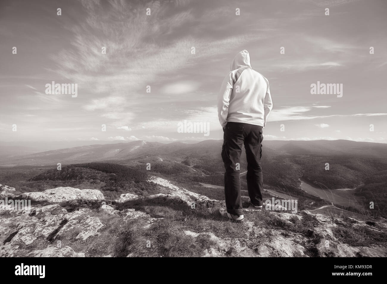 Viajero en la cima de la montaña. Diseño conceptual en tonos de blanco y negro. Foto de stock