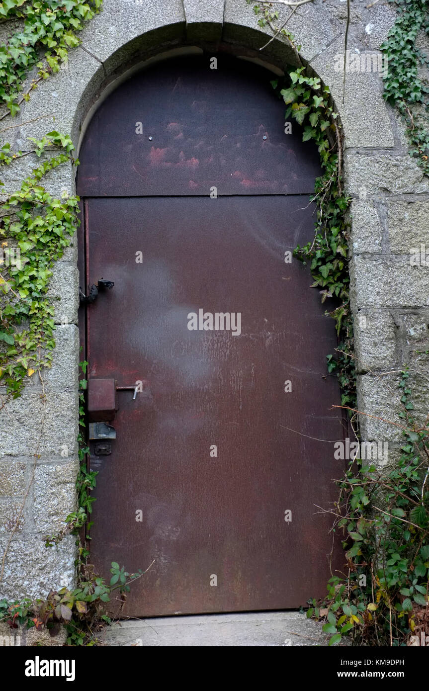 Una oxidada puerta de seguridad de acero montado en una antigua iglesia cerradas Foto de stock
