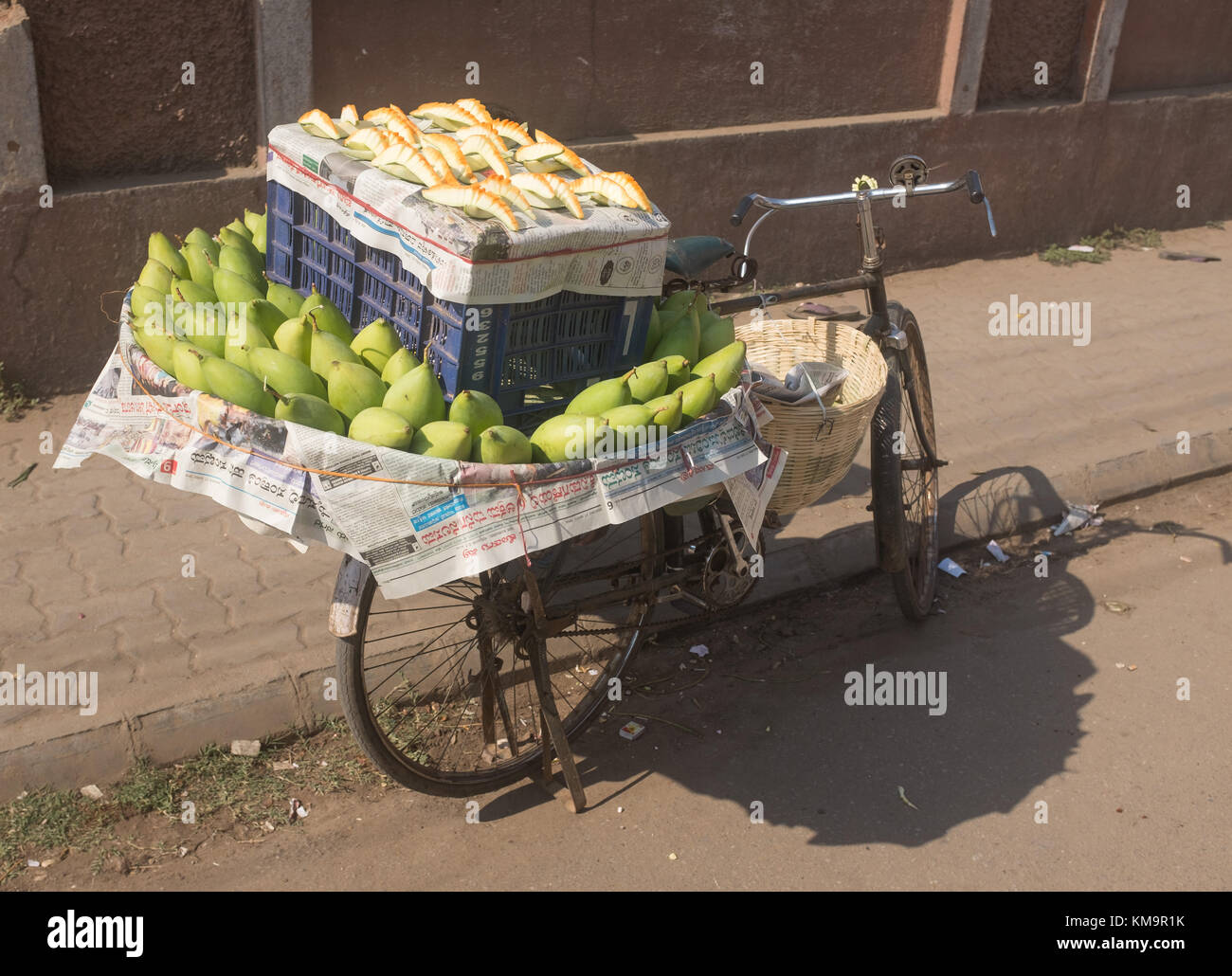 Raw recién cortadas mangos mantenidos para la venta en bicicleta aparcada en la calle de Mysore, mysuru, Karnataka, India. Foto de stock